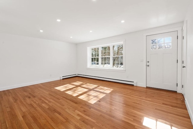 foyer featuring light wood-type flooring, a baseboard radiator, baseboards, and recessed lighting