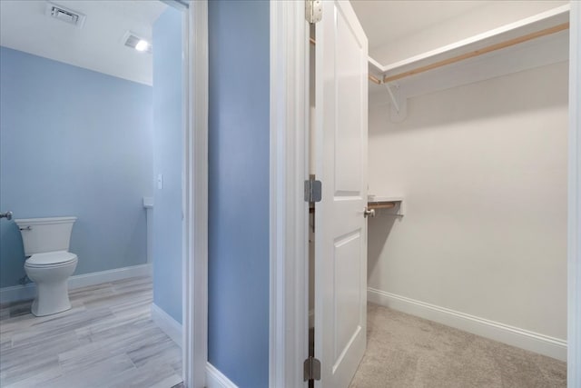 bathroom featuring wood-type flooring and toilet