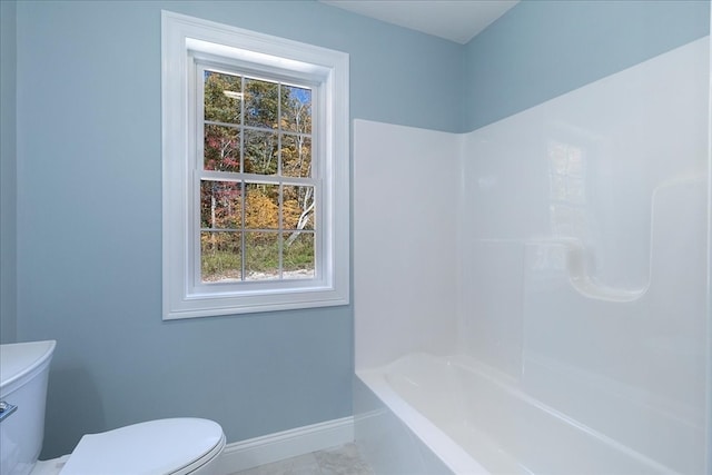 bathroom with toilet, a healthy amount of sunlight, and tile patterned floors