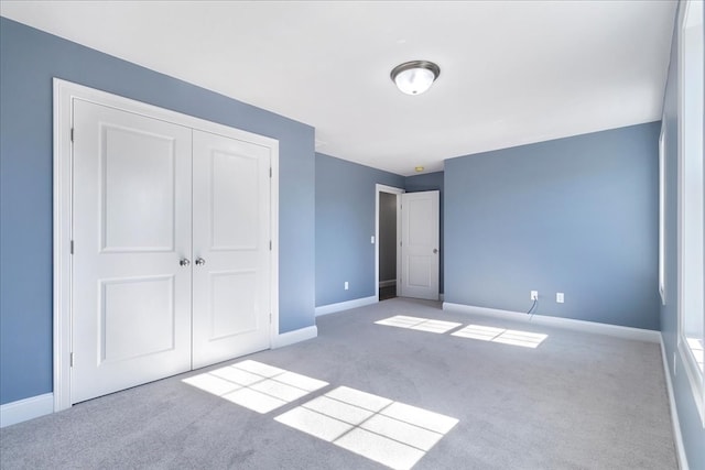 unfurnished bedroom with a closet and light colored carpet