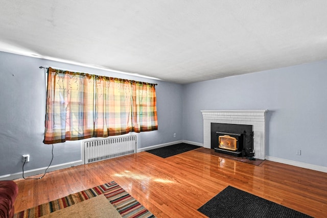 unfurnished living room with wood-type flooring and radiator