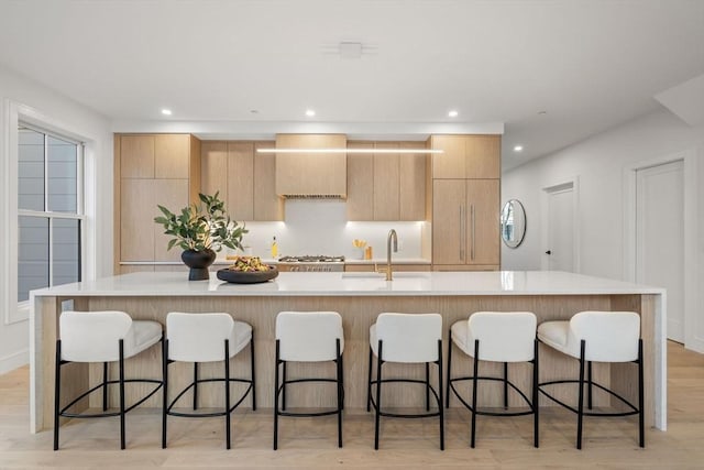 kitchen with a kitchen bar, a spacious island, and sink