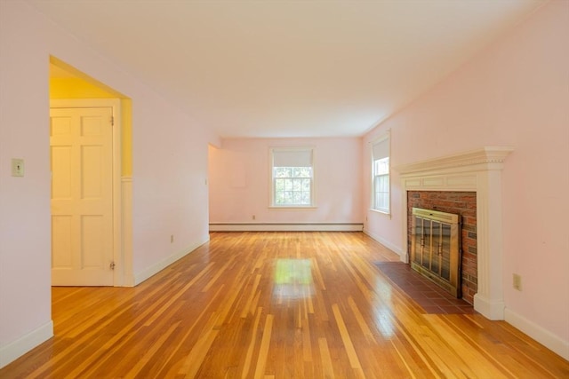 22 Liberty St, Bellingham, MA 02019 - unfurnished living room featuring a baseboard heating unit, light wood-style floors, and a fireplace
