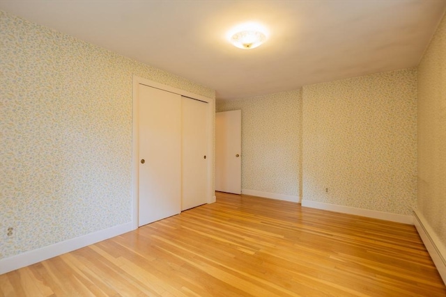22 Liberty St, Bellingham, MA 02019 - unfurnished bedroom with wallpapered walls, light wood-style floors, a baseboard heating unit, and a closet