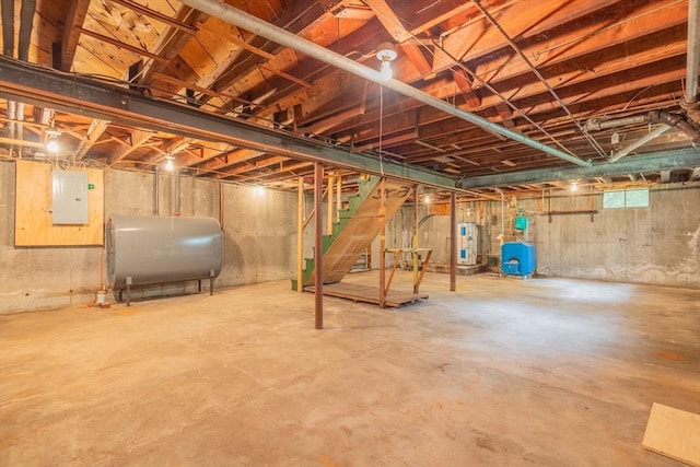 22 Liberty St, Bellingham, MA 02019 - unfinished basement with oil tank, electric water heater, electric panel, a water pressure tank, and stairway