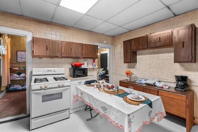 439 Walnut Ave, Boston, MA 02119 - kitchen featuring white gas range, black microwave, a drop ceiling, and light countertops