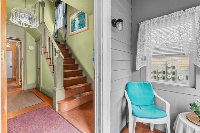 439 Walnut Ave, Boston, MA 02119 - stairway featuring wood finished floors, a chandelier, and baseboards