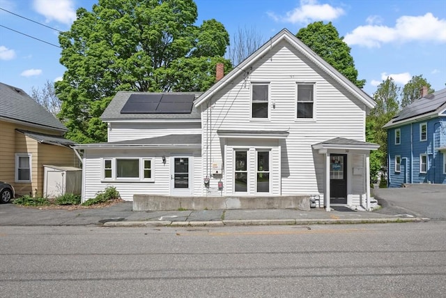 10 Jackson St, Ayer, MA 01432 - view of front facade with solar panels and a chimney