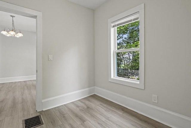 10 Jackson St, Ayer, MA 01432 - empty room featuring a chandelier, baseboards, and wood finished floors