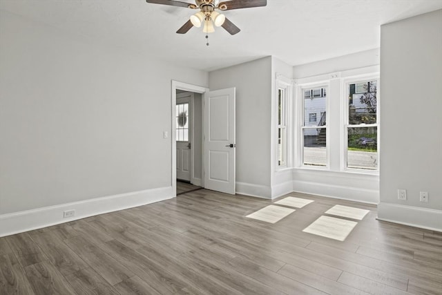 10 Jackson St, Ayer, MA 01432 - unfurnished bedroom with multiple windows, wood finished floors, and baseboards