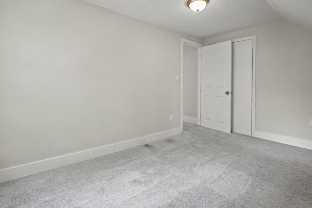 10 Jackson St, Ayer, MA 01432 - unfurnished bedroom featuring light carpet, vaulted ceiling, baseboards, and a closet