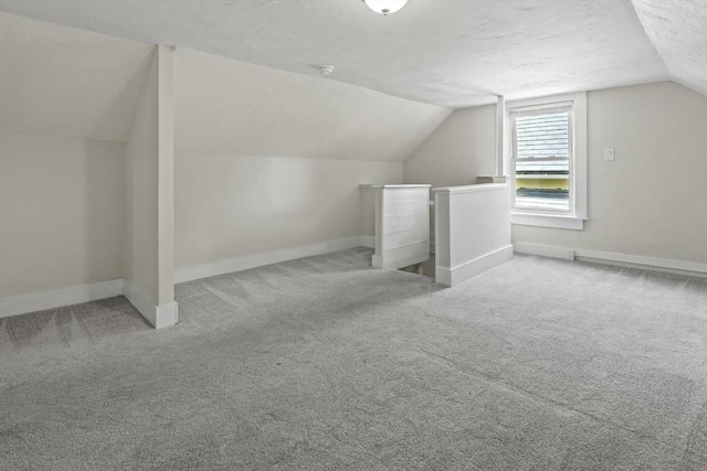 10 Jackson St, Ayer, MA 01432 - bonus room with baseboards, lofted ceiling, carpet, and a textured ceiling
