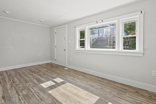 10 Jackson St, Ayer, MA 01432 - empty room featuring healthy amount of natural light, baseboards, wood finished floors, and crown molding