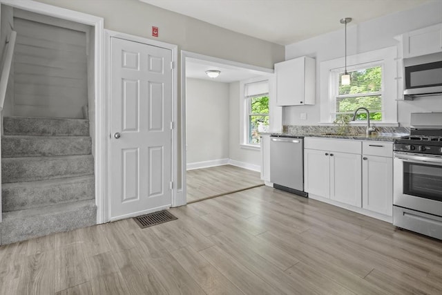 10 Jackson St, Ayer, MA 01432 - kitchen with stainless steel appliances, a sink, white cabinets, stone counters, and decorative light fixtures