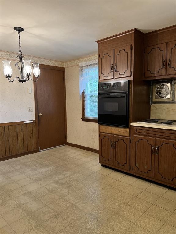 50 Feltham Rd, Springfield, MA 01118 - kitchen with black oven, light flooring, wallpapered walls, a chandelier, and baseboards