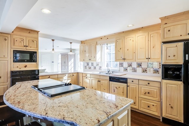 kitchen featuring tasteful backsplash, decorative light fixtures, sink, dark hardwood / wood-style floors, and black appliances