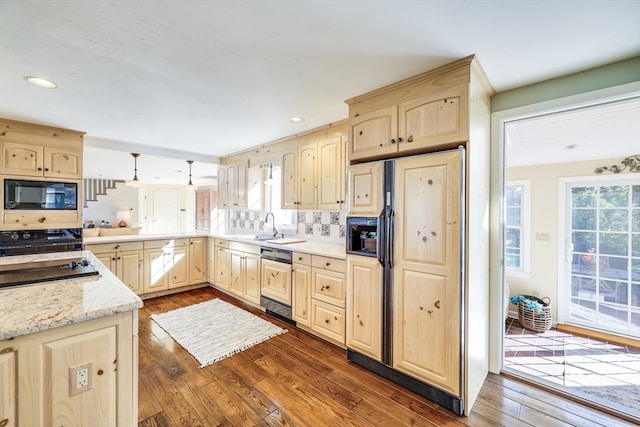 kitchen featuring hanging light fixtures, dark hardwood / wood-style floors, black appliances, and a healthy amount of sunlight