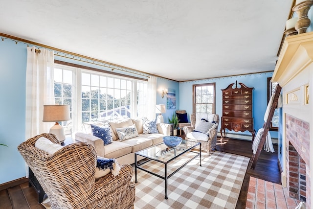 living room featuring a fireplace, crown molding, and hardwood / wood-style flooring