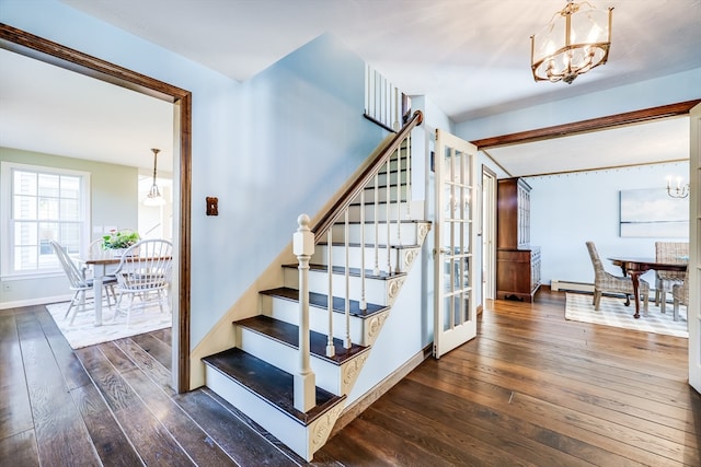 staircase featuring an inviting chandelier and hardwood / wood-style flooring