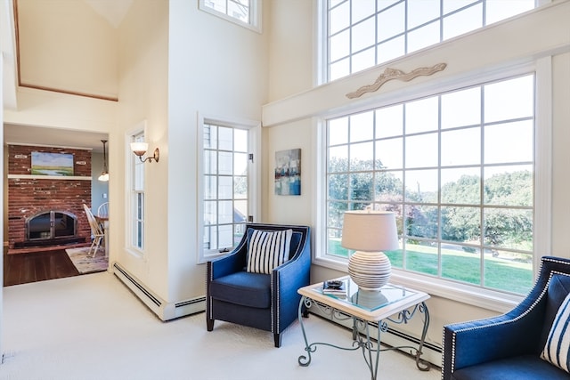 living area featuring a fireplace, a high ceiling, and carpet