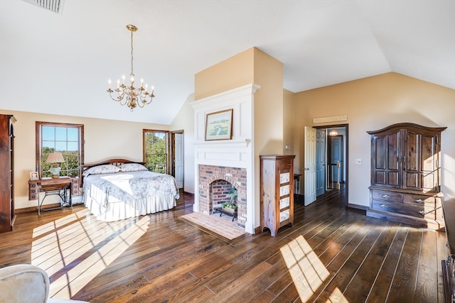 bedroom featuring a brick fireplace, dark hardwood / wood-style floors, vaulted ceiling, and a chandelier