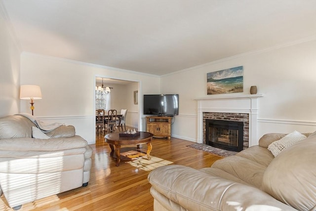 16 Kirsi Cir, Westford, MA 01886 - living room with crown molding, wood finished floors, a chandelier, and a brick fireplace