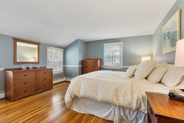 16 Kirsi Cir, Westford, MA 01886 - bedroom featuring light wood-style flooring, multiple windows, vaulted ceiling, a baseboard heating unit, and baseboards