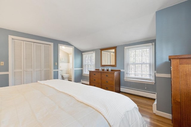 16 Kirsi Cir, Westford, MA 01886 - bedroom featuring a baseboard radiator, wood finished floors, vaulted ceiling, baseboards, and ensuite bathroom