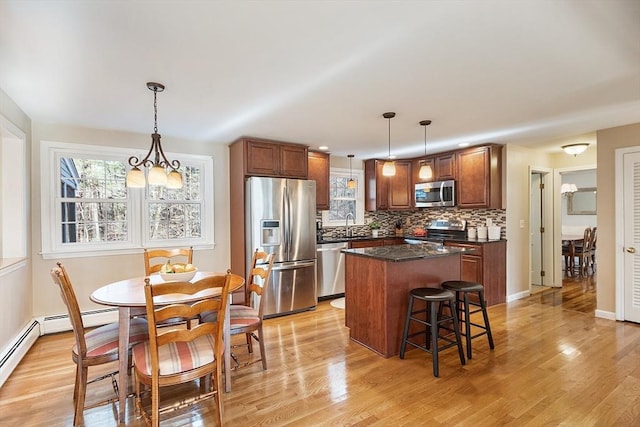 16 Kirsi Cir, Westford, MA 01886 - kitchen featuring stainless steel appliances, a center island, tasteful backsplash, light wood finished floors, and a kitchen breakfast bar