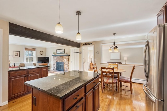 16 Kirsi Cir, Westford, MA 01886 - kitchen with freestanding refrigerator, light wood finished floors, a glass covered fireplace, a center island, and beam ceiling