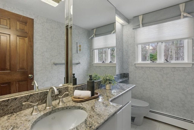 bathroom with vanity, toilet, plenty of natural light, and a baseboard radiator