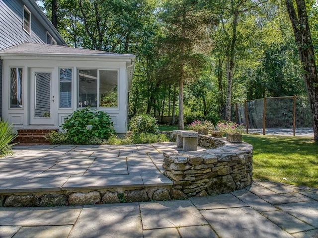 view of patio / terrace with a sunroom and fence