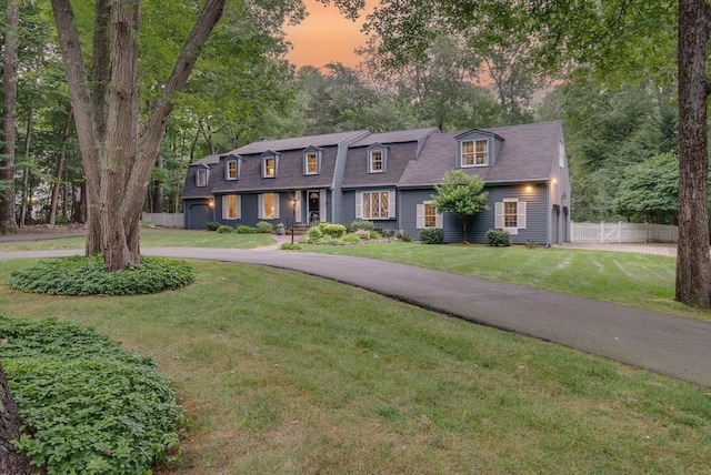 view of front of house with a lawn, fence, and driveway