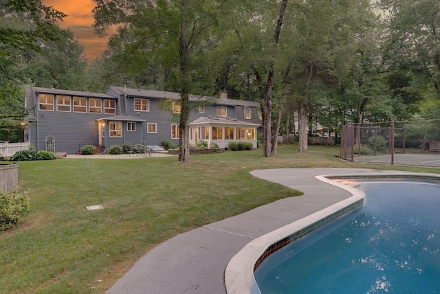 view of pool featuring a lawn and fence