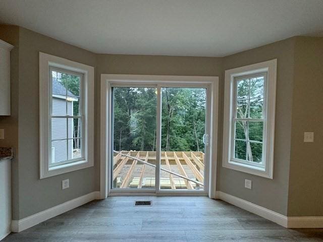 entryway with light wood-type flooring, a wealth of natural light, and baseboards