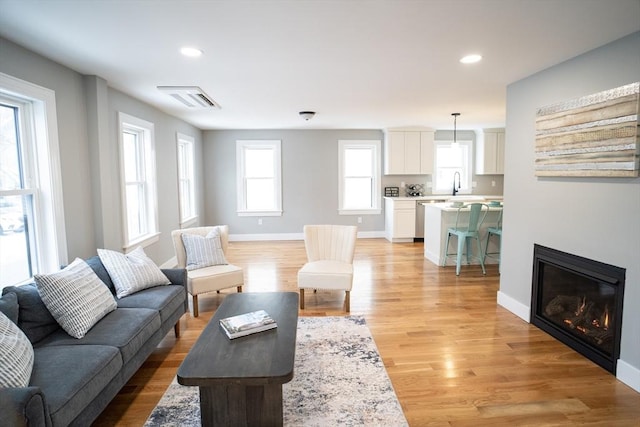 living room featuring sink and light hardwood / wood-style flooring