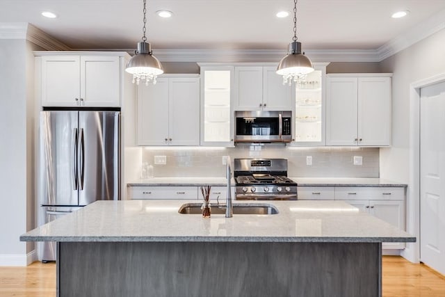 kitchen with stainless steel appliances, white cabinets, and crown molding