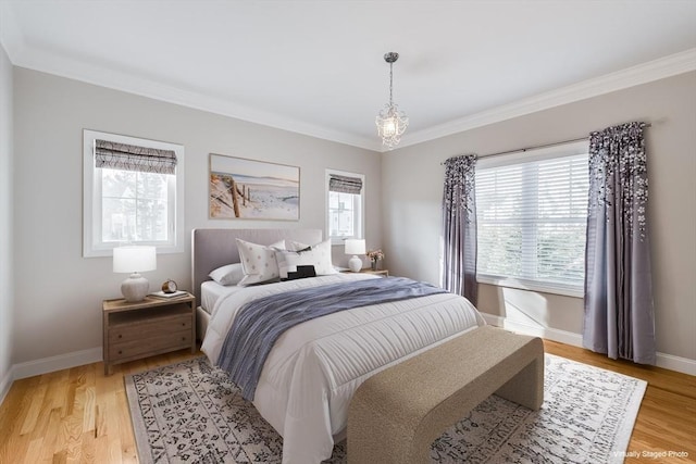 bedroom featuring crown molding, light wood-type flooring, and baseboards