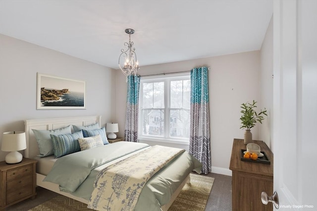 bedroom featuring baseboards, a chandelier, and dark carpet