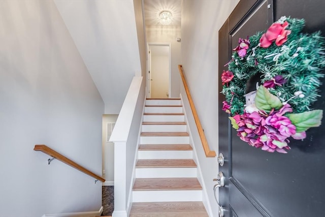 stairway with baseboards and wood finished floors