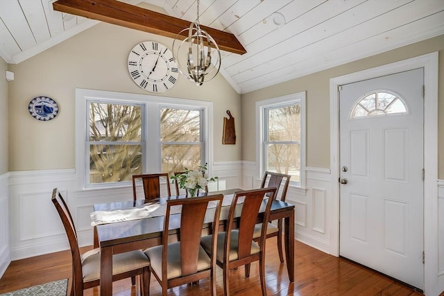 dining space featuring dark wood-type flooring, a chandelier, wood ceiling, and vaulted ceiling with beams