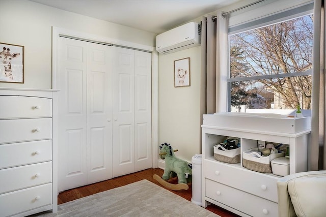 bedroom featuring a closet, dark wood-type flooring, and a wall mounted air conditioner