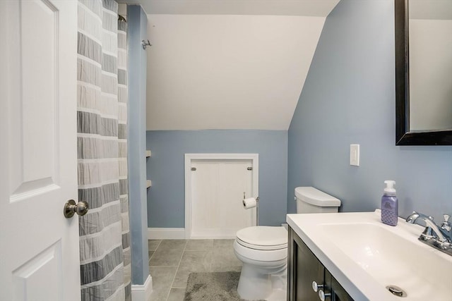 bathroom featuring toilet, vanity, and vaulted ceiling