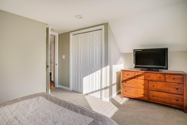 carpeted bedroom with vaulted ceiling and a closet