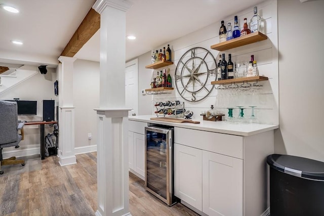 bar featuring light wood-type flooring, white cabinetry, wine cooler, and tasteful backsplash