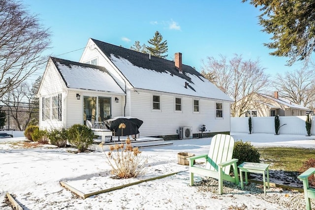 snow covered back of property featuring a deck