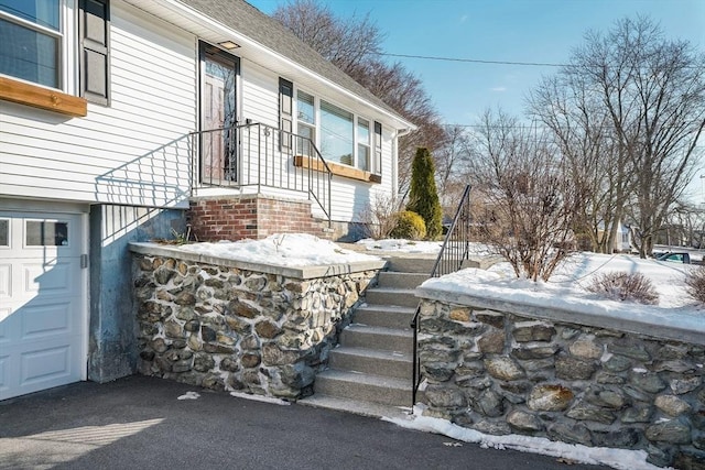 view of snow covered exterior featuring a garage