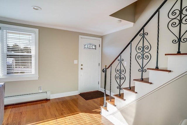 foyer entrance featuring a baseboard radiator, light hardwood / wood-style flooring, and ornamental molding