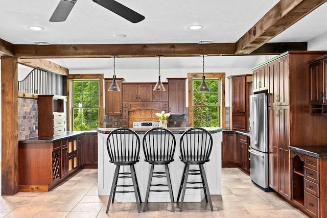 3 Side Hill Rd, Hingham, MA 02043 - kitchen with freestanding refrigerator, a breakfast bar, a center island, dark countertops, and ceiling fan