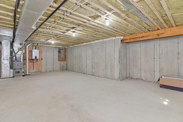 basement with electric panel, water heater, and heating unit